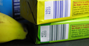 Barcodes on packets of gum laying on top of supermarket check-out counter.