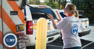 Female student from SUNY New Paltz washes an amublance at the rescue squad during Service Day.