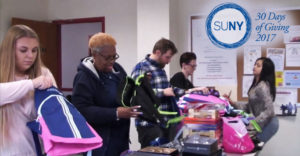 Students at Schenectady County Community College fill backpacks with gifts for children.