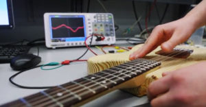 A guitar is hooked up to a computer monitor that measures sound waves for the start-up company BitCrusher.