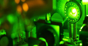 Green laser light shines on metal lab tools.