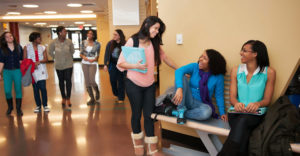 Groups of diverse students mingle in a hallway at Farmingdale State College.