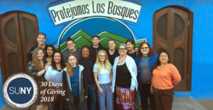 Onondaga Community College students stand together in fron of a building in Guatemala.