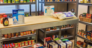 A food pantry with lots of non-perishable food stuff on the shelves.