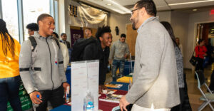 Event table at Westchester Community College with minority students talking to college representatives.
