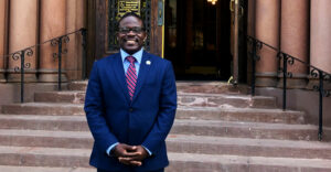 Albany city councilman Owusu Anane stands in front of city hall.