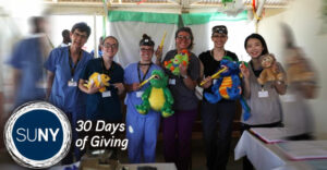 SUNY Broome dental students pose with stuffed animals in a medical tent.