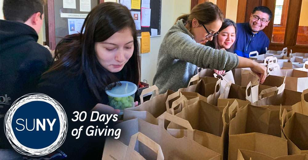 A female Dutchess Community College student packs food into paper bags.