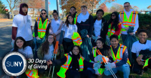 Farmingdale State College studets pose outside in from of their Adopt-A-Highway sign.