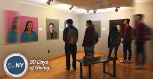 SUNY Poly students gather iin art gallery to look at exhibits.