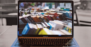 Laptop on table with a picture of hardcover books on screen.