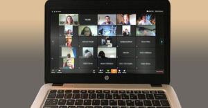 A laptop shows a student virtual mmeeting taking place on Zoom.