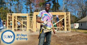 Alfred State student Christopher Phillips gives a thumbs up while working to build a house with Habitat for Humanity in Myrtle Beach, SC.
