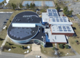 An Aerial View Of Solar Arrays On A Suny New Paltz Building Rooftop.