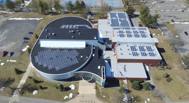 An aerial view of solar arrays on a SUNY New Paltz building rooftop.
