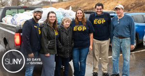 SUNY Canton students and staff stand in front of pick-up truck loaded with clothes and goods for refugees.