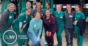 Group of SUNY Delhi nursing students pose for a group photo in their nursing scrubs.
