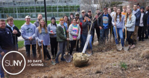 SUNY Morrisville students pose for a picture during tree planting activity on campus.
