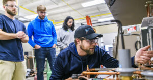 Students work on pipes and mechanical components during a class at Hudson Valley Community College.