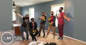 Corning Community College students pose for a picture inside a house they are building with Habitat For Humanity.