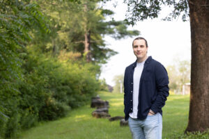Cole Albrecht stands in a field near SUNY Adirondack's campus