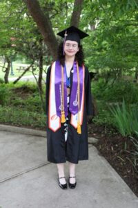 Victoria Akiki stands in graduation regalia