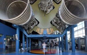 Abby Greco stands in front of a large rocket.