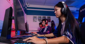 Female student playing video games in esports competition.