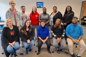 Students pose on chairs and stand together