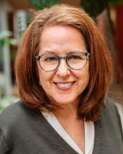 Headshot of Professor Audrey Bernstein with a blurred, natural background 