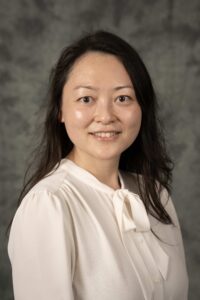 Headshot of Professor Jieshu Wang with a dark background 